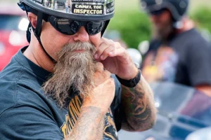 Biker adjusting beard and helmet