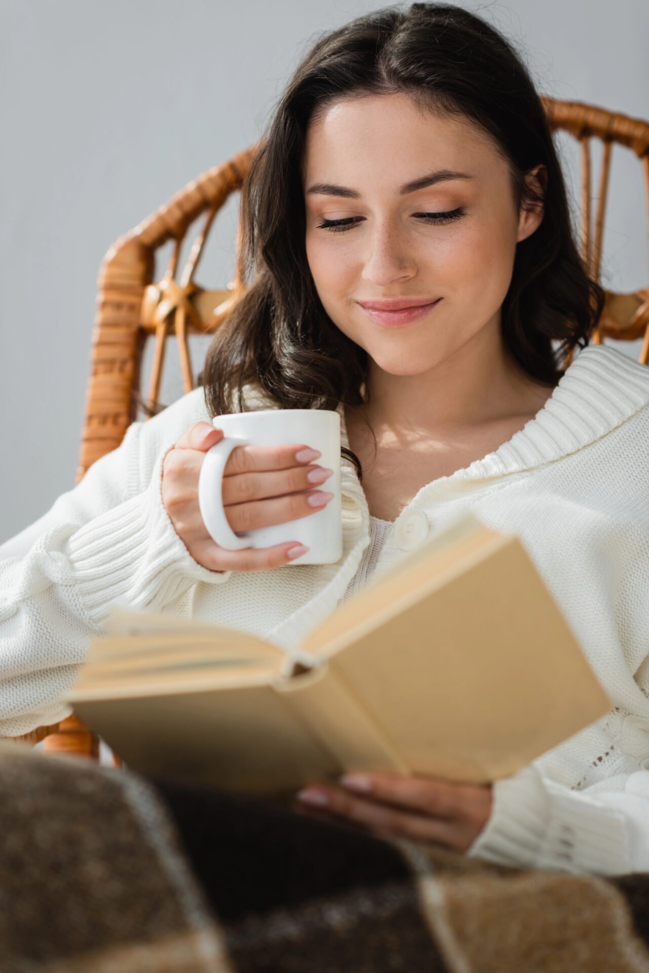 Woman reading book with coffee mug
